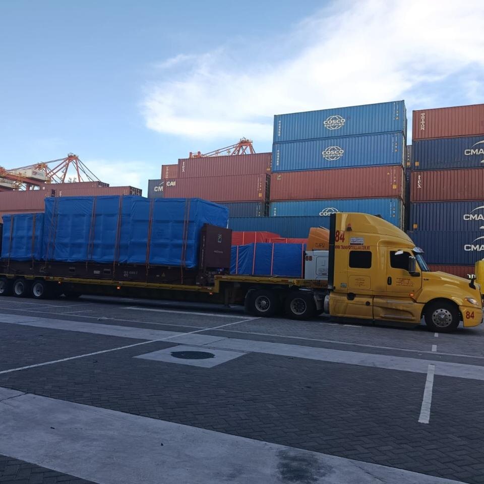 Unidad LUJAV 84 con carga sobredimensionada sobre flat rack en un patio de contenedores